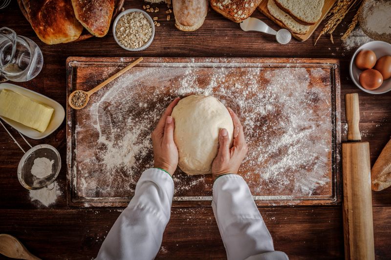 Artisanal bakery: Artisan Chef Hands kneading dough. Artisanal bakery is bread made by a craftsperson using mainly traditional techniques.