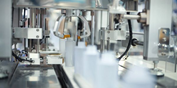 Robotic arm handling cylindrical containers on a production line.