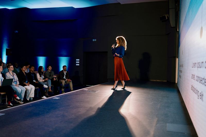 Professional speaker presenting on advancements at a technology event with engaged audience