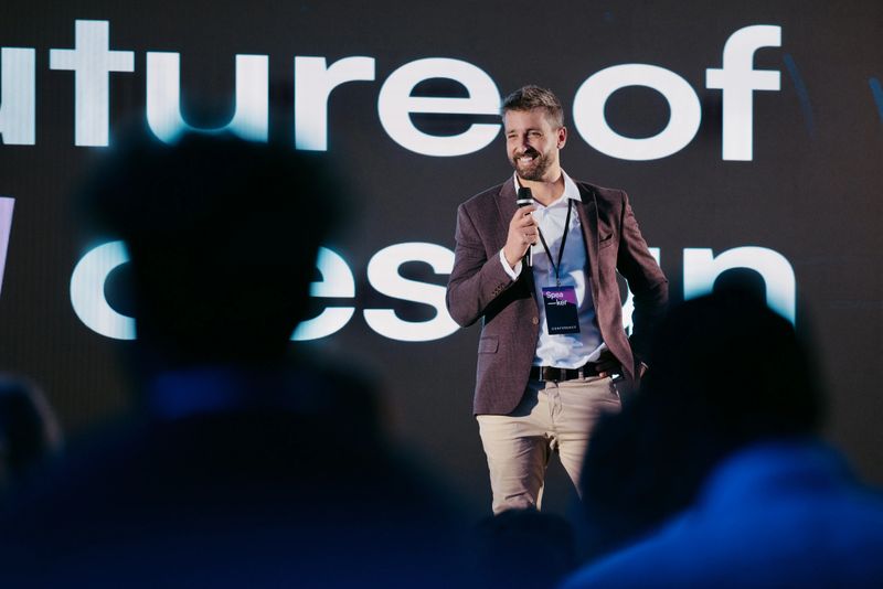 A professional speaker discusses AI advancements on stage during a technology conference.