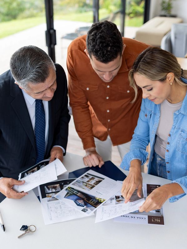 Three people reviewing property documents together.