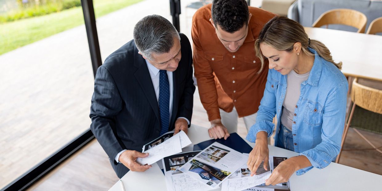 Three people reviewing documents at a table.