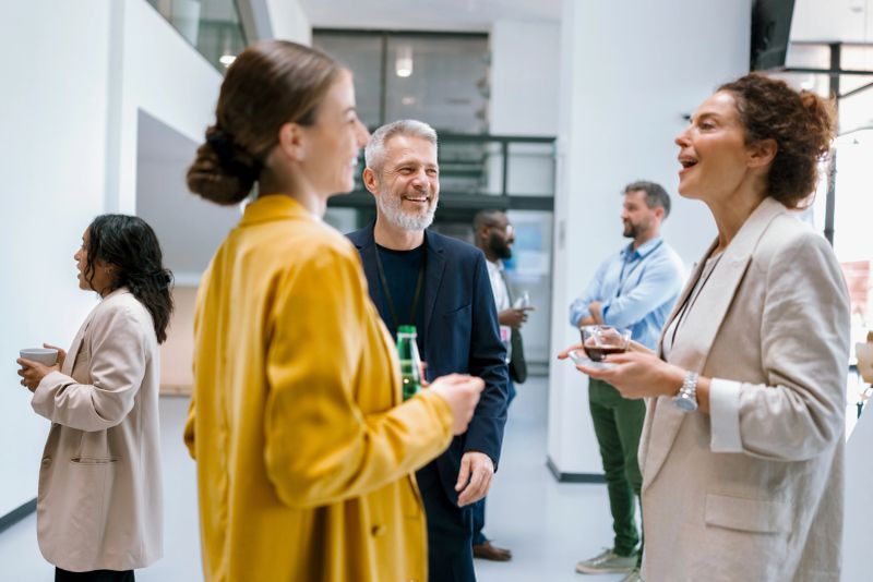 Business people enjoying conversation with diverse colleagues during break from conference