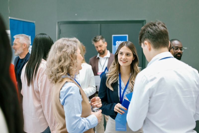 Young female entrepreneur discussing with delegates during networking event at convention centar