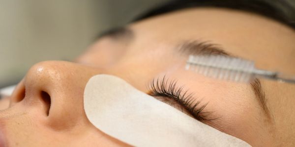 Close-up of eyelash grooming with patch under eye.