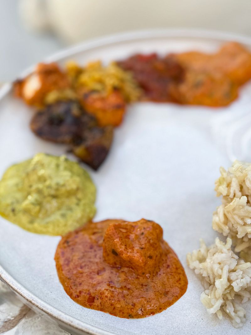 Stock photo shows a vibrant plate of mixed Indian takeaway buffet dishes showcases authentic flavors, featuring Bombay potatoes, creamy chicken korma, rich tikka masala, and fragrant biryani. Each dish highlights colorful spices and textures, reflecting the diversity of traditional Indian cuisine