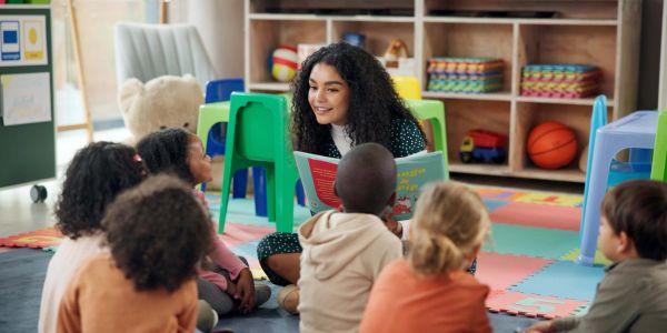 Teacher reading a book to children in a classroom.