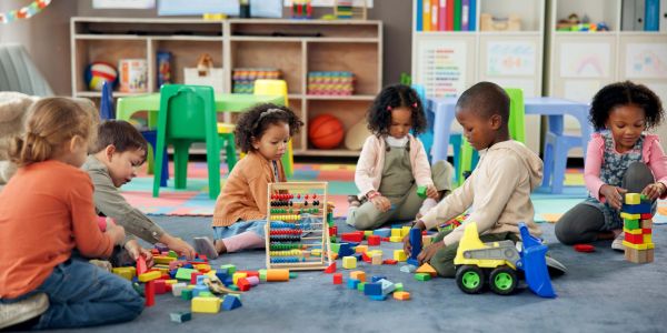 Children playing with colorful blocks and an abacus together.