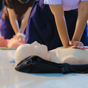 Person practicing CPR on a mannequin.