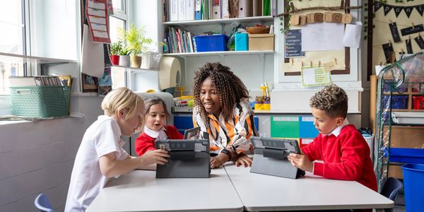 Teacher and students using tablets in a classroom.