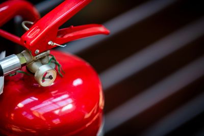 Close-up of a red fire extinguisher with pressure gauge.