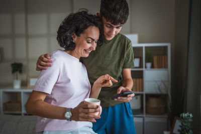 Mother and son looking at a smartphone and smiling.