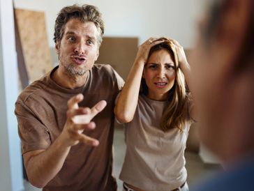 A distressed couple arguing intensely with a third person.