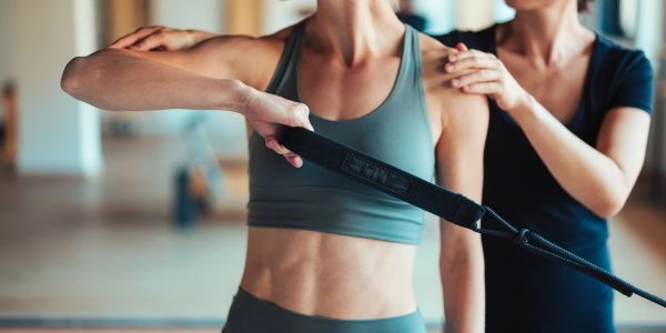 Woman exercising with trainer assistance.