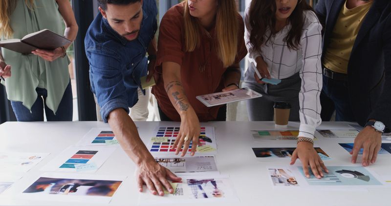 Creative, meeting and business people with documents for planning, brand design and portfolio. Collaboration, teamwork and workers with notes, color palette and project layout for marketing strategy