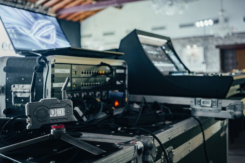 Equipment ready for audio and video transmission at a live event. Wireless video transmitter, connection rack, laptop, and audio mixer.