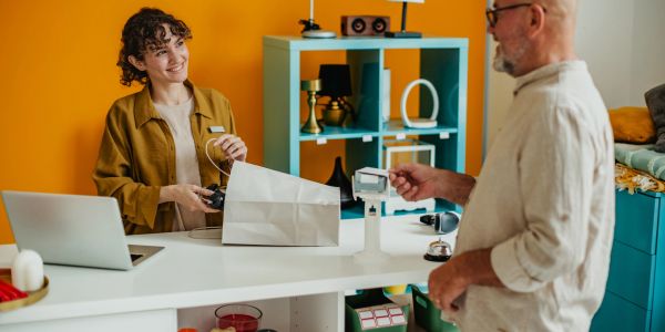 Customer paying at a store counter with a smiling cashier.