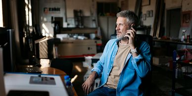 Man talking on phone in a casual workspace.