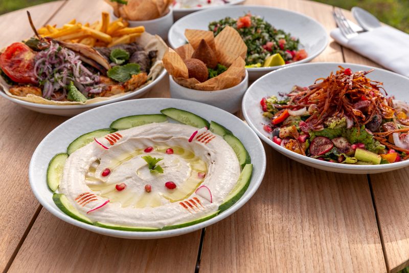 Arabic food variety mezze appetizer variety of dishes with Hummus, moutabel, labenah, mixed grill for Middle East gourmet meal served on wood table