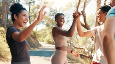 Friends celebrating outdoors with high fives.