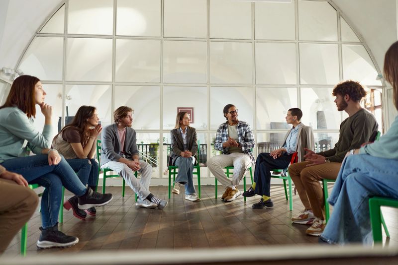 Large group of happy freelancers communicating during a group therapy in a modern office. Copy space.