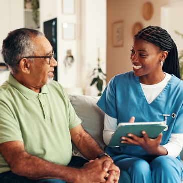 Nurse talking to elderly man with a tablet.