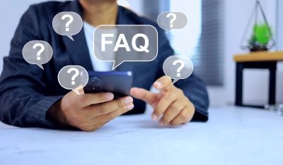 Person using phone with FAQ and question marks icons.