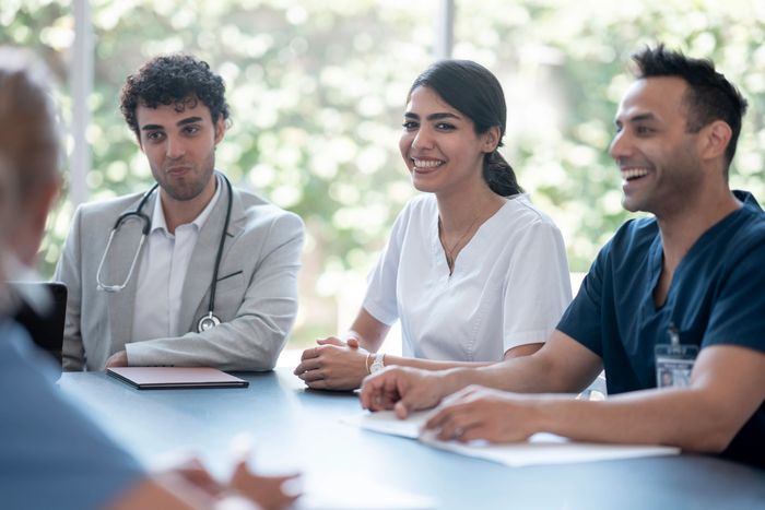 Medical professionals having a cheerful meeting around a table.