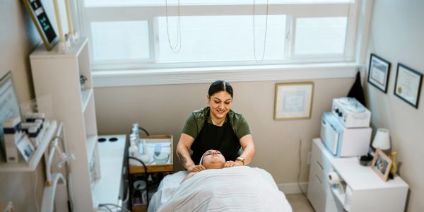 A woman giving a facial massage in a spa.
