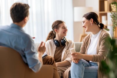 A family happily talking together in a living room.
