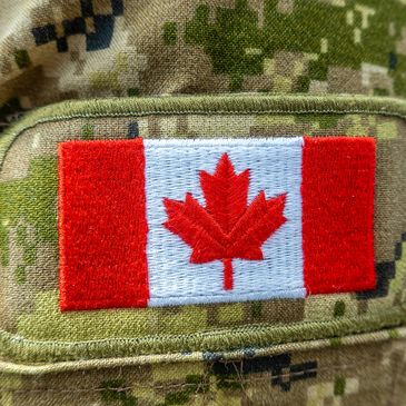 Canadian flag patch on camouflage military uniform.