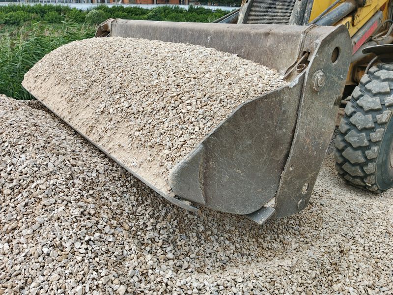 laying crushed stone using a loader for road construction