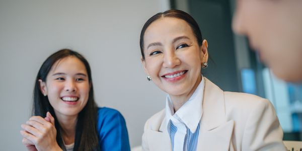 two women in professional attire smiling