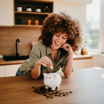 Happy woman saving money in a piggy bank.