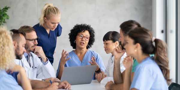 Medical team discussing around a laptop.