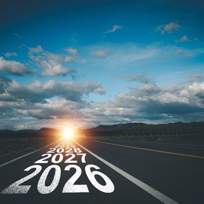 Road with future years marked, leading to a bright horizon under a cloudy sky.