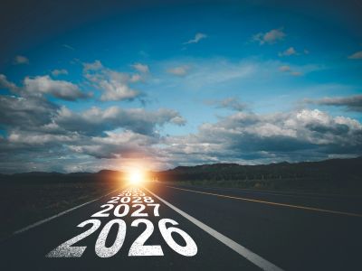 A road with years 2026, 2027, and 2028, leading to a sunrise.