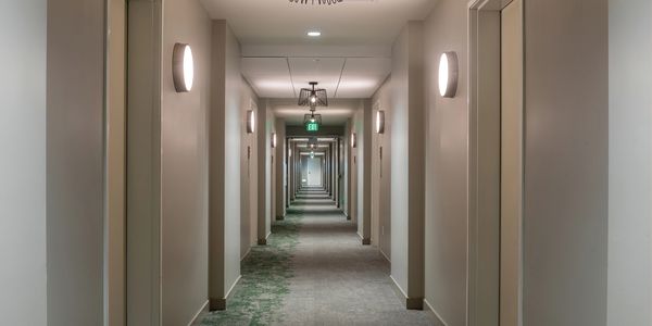Long hotel corridor with closed doors on both sides.