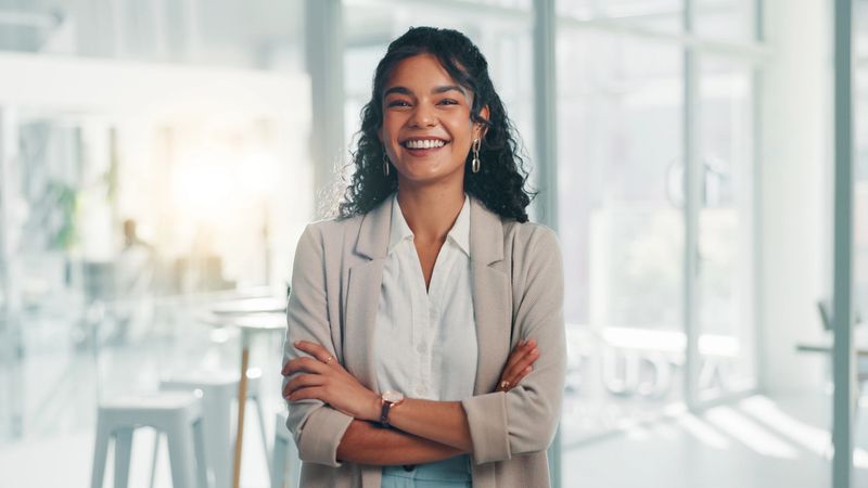 Portrait, smile and confident business woman in corporate office for ambition, finance or investment at venture capital. Happy, professional employee and worker with arms crossed for private equity