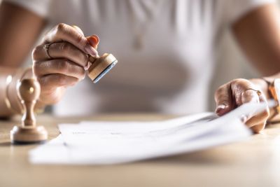 Person stamping a document on a table.