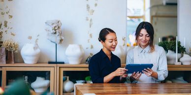 Two women looking at a tablet together in a cozy room.