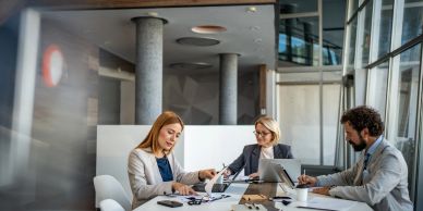 Three professionals collaborating in a modern office.