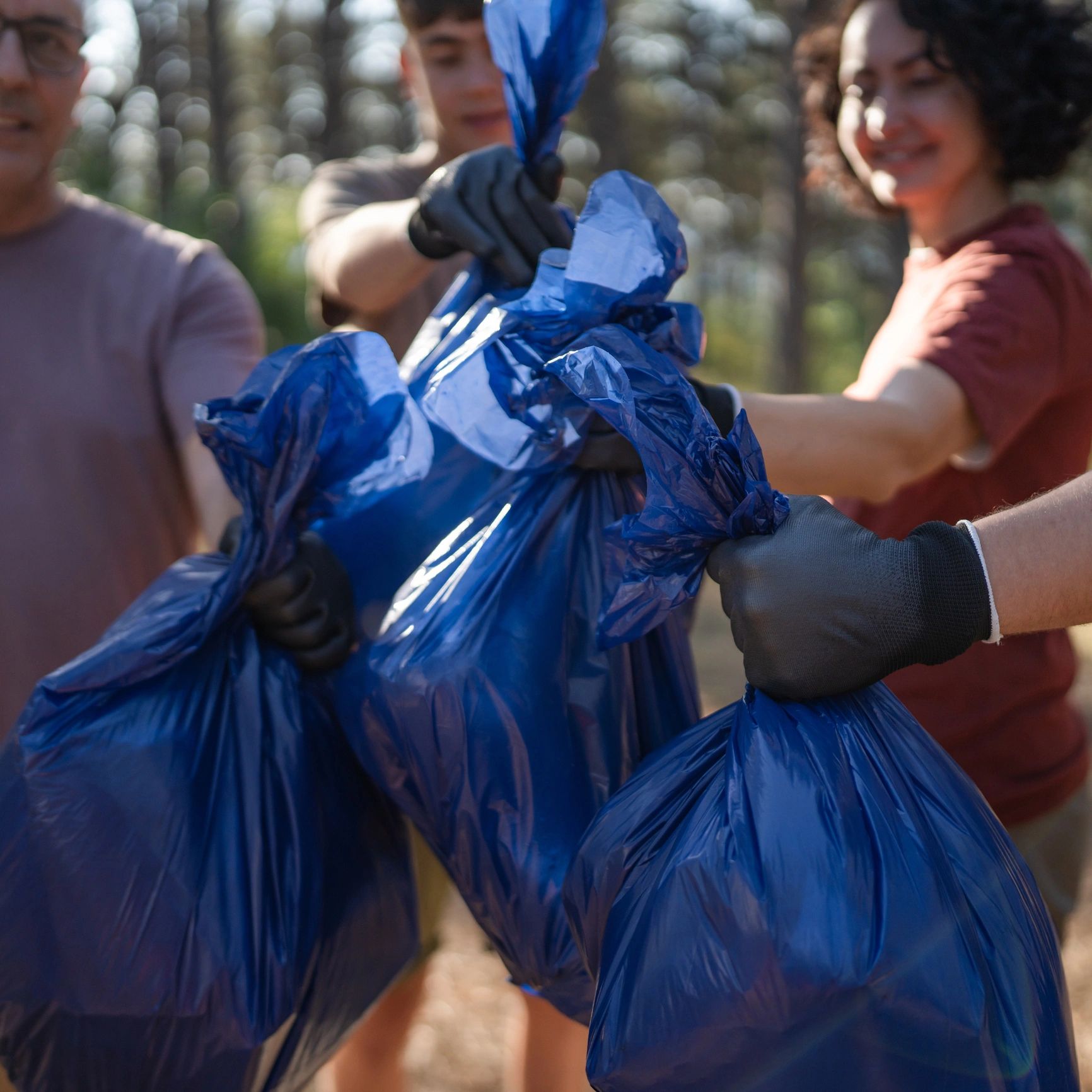 A group holding blue trash bags during a cleanup activity.