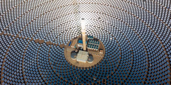 A solar power tower surrounded by a field of solar mirrors.