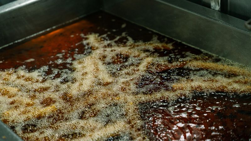 Delicious churros frying in hot oil in an industrial kitchen