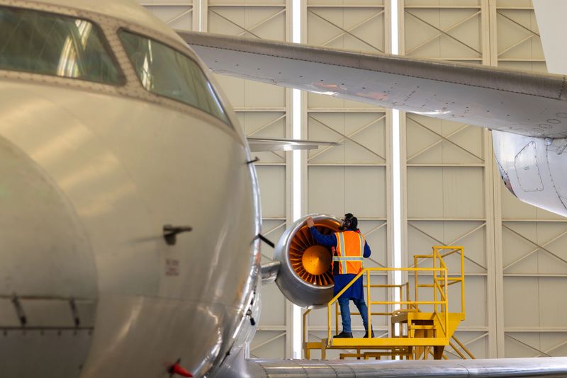 Aviation engineer checking one of the engines of a commercial airplane