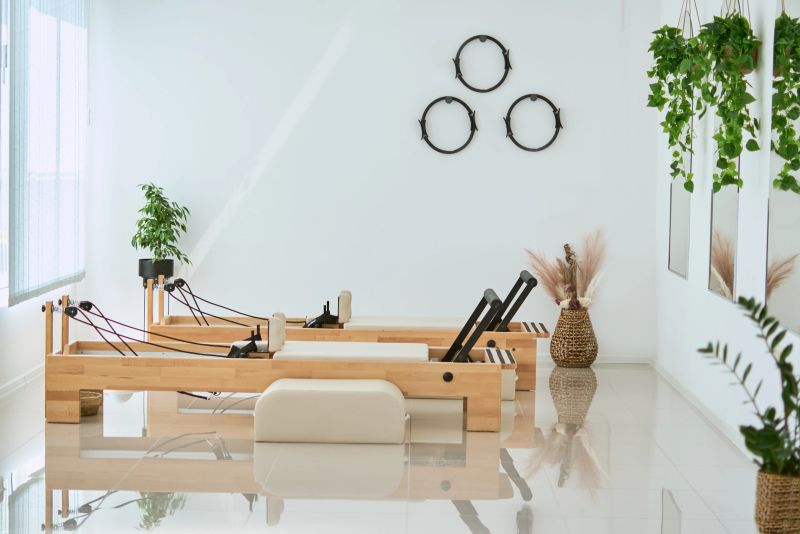 Beautiful space featuring wooden machine, white design, mirrors and high end fitness equipment with soft sunlight.