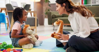 Woman and child playing with stuffed animals.