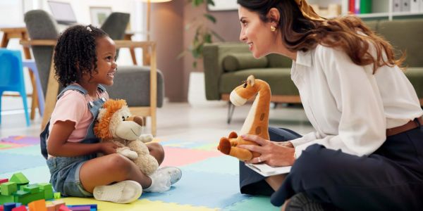 Woman and child playing with stuffed animals.