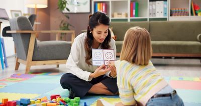 Therapist using emotion cards during a child therapy session.